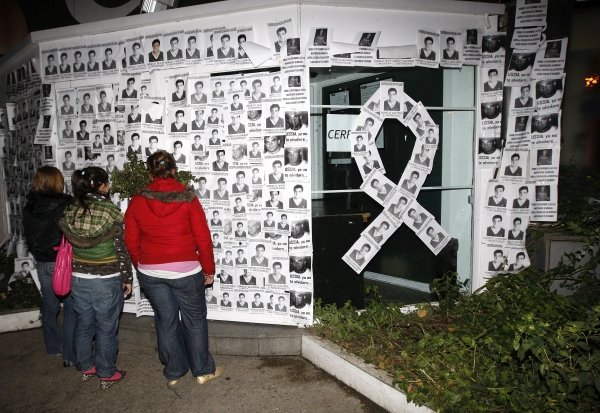 Varios jóvenes observan la fachada de la discoteca 'El balcón de los rosales', empapelada con fotos de Álvaro Ussía. (Foto: EFE)