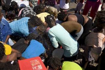 Un grupo de persona lucha entre sí por obtener agua en Puerto Príncipe.