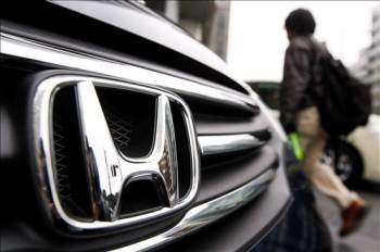 Un hombre pasa por delante de un coche Honda frente a la sede de la firma japonesa en Tokio. (Foto: Dai Kurokawa)