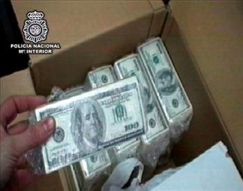 Un agente muestra fajos de billetes falsos de dólar estadounidense preparados para su distribución. (Foto: EFE)