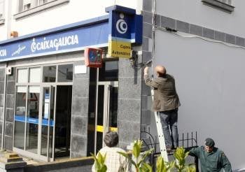 Miembros de la Guardia Civil inspeccionan la fachada de una sucursal bancaria.
