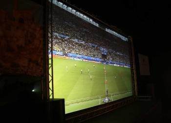 Un partido de fútbol visualizado en una pantalla gigante
