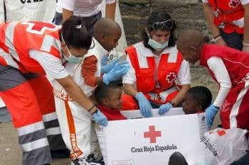 Cuatro niños juegan con los guantes y cajas de Cruz Roja tras llegar a Algeciras. (Foto: Archivo)