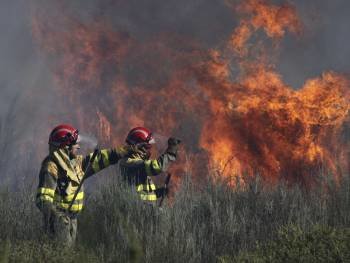 Dos operarios controla un fuego declrado el pasado mes de marzo en Cualedro. (Foto: XESÚS FARIÑAS)