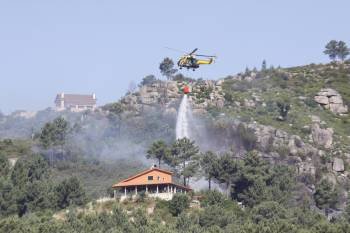 Un helicóptero descarga agua sobre el fuego.