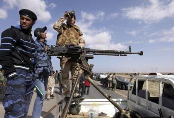  Rebeldes libios hacen guardia en el último control de seguridad en la carretera que comunica Ajdabiya y Bengasi, en el este de Libia.