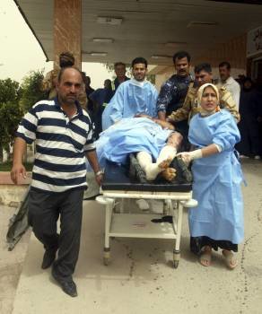 Un hombre es trasladado un hospital después de resultar herido a causa de una de las tres bombas detonadas en un doble atentado y otro ataque en la ciudad iraquí de Kirkuk.