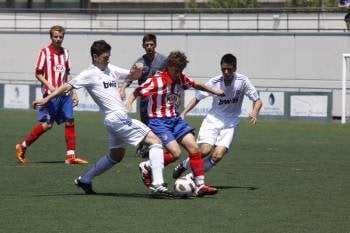 Dos jugadores del Real Madrid intenan arrebatarle el balón a un atacante del Atlético. (Foto: X.Fariñas)