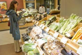 Una mujer examina alimentos en un mercado. (Foto: EFE)