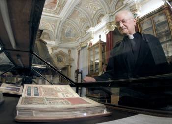 El deán José María Díaz observa una edición facsímil del Códice Calixtino. (Foto: LAVANDEIRA)