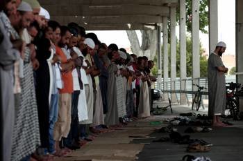 Un grupo de musulmanes rezando ayer en la calle en Lleida, al inicio del mes del Ramadán (Foto: DAVID BESORA)