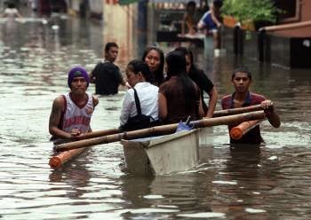 Habitantes se trasladan por calles inundadas hoy, martes 2 de agosto de 2011, en una canoa en San Juan City, al este de Manila (Filipínas). EFE