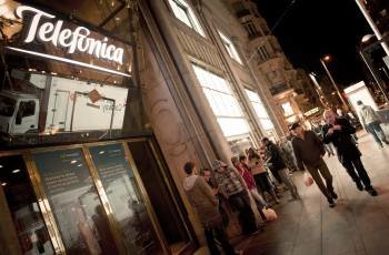 Decenas de personas hacen cola a las puertas de la emblemática tienda de Telefónica de la Gran Vía de Madrid para comprar el nuevo iPhone 4S