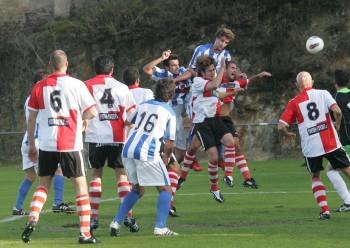 Un delantero del Celanova se eleva entre los defensores del Arosa para cabecear un balón. (Foto: MARCOS ATRIO)