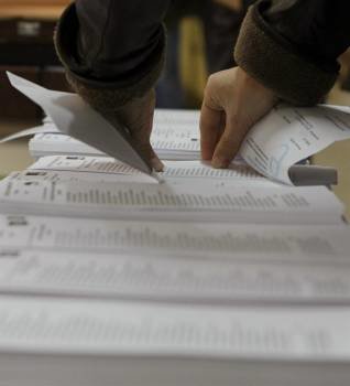  Un ciudadano coge una papeleta de votación en un colegio electoral