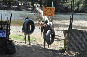 Jóvenes aventureros provistos de neumáticos se dirigen al río Nong, en Laos, para practicar 'tubing', una actividad consistente en descender con ese artilugio un tramo del cauce fluvial (Foto: EFE)