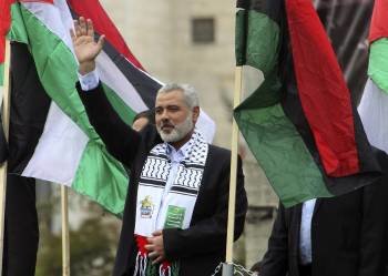 El líder de Hamás Ismail Haniye (c) ondea una bandera de Hamás y otra de Palestina durnte la celebración del 24º aniversario de la fundación del movimiento islamista, en Gaza