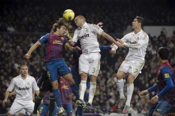 Las cabezas de Pepe y Puyol buscan el mismo balón en el clásico del Bernabéu. (Foto: E. NARANJO)