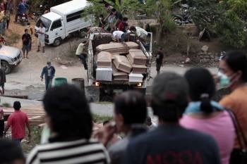 Un camión llega cargado de ataúdes con los cuerpos sin vida de alguna de las víctimas de las inundaciones, antes del inicio de un funeral múltiple en Iligan.