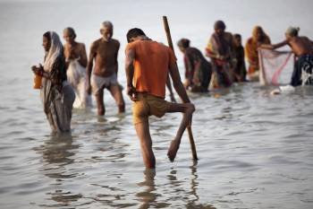Varias personas se purifican en la orilla del río Ganges en la víspera del 'Makar Sankranti' uno de los festivos más importantes en el calendario hindú, en Gangasagar, isla de Sagar, bahía de Bengala (India) (Foto: EFE)