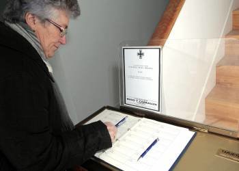 Una vecina de Vilalba firma en el libro de condolencias en la vivienda familiar de Manuel Fraga