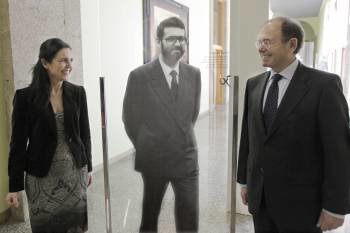 García Escudero, visitando la exposición 'Aqueles primeiros anos', ante una imagen de Rajoy. (Foto: LAVANDEIRA)
