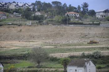 Terrenos explanados en A Farixa, donde Eroski proyecta su centro comercial, en los que solo queda una excavadora abandonada. (Foto: MARTIÑO PINAL)