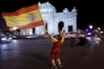 Las estatuas de los dioses Cibeles y Neptuno se cubren hoy con sendas banderas de España para celebrar el triunfo de la Selección