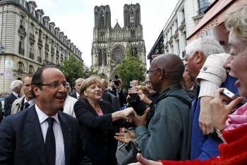Hollande y Merkel saludan a un grupo de ciudadanos ante la catedral de Reims. (Foto: HOHEM GOUVEIA)