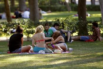Un grupo de personas toman el sol en un parque. (Foto: ZIPI)