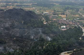 Los restos del incendio, sofocado, y el pueblo de Oimbra, al fondo. (Foto: MARCOS ATRIO)