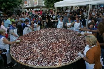 Las pulpeiras aliñan las raciones en el plato gigante, en la Plaza Mayor. (Foto: MARCOS ATRIO)