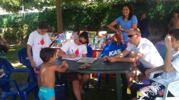 Los voluntarios entregan juegos a un menor. Las instalaciones están dentro del recinto de la piscina. (Foto: V. R.)