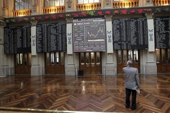 Un hombre contempla el panel de la Bolsa de Madrid que refleja la evolución del IBEX 35 (Foto: EFE)
