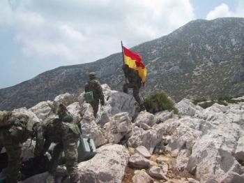 Un militar español enarbola la bandera de España en 2002.