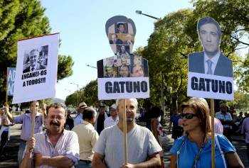 Manifestantes con pancartas con el retrato del primer ministro de Portugal, Passos Coelho.  (Foto: A. COTRIM)