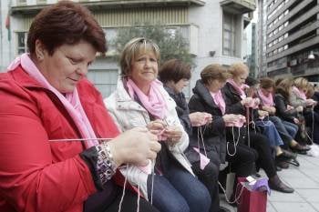 Mujeres tejiendo la bufanda rosa. (Foto: MIGUEL ÁNGEL)