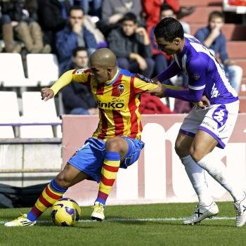  El centrocampista argelino del Valencia Sofiane Feghouli (i) protege el balón ante la defensa del jugador del Real Valladolid, Carlos González Peña  (Foto: EFE)