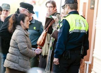 Sara L.H., acompañada de agentes de la Guardia Civil y de la Policía Local entra en su casa de Pilas (Sevilla). (Foto: RAUL CARO)