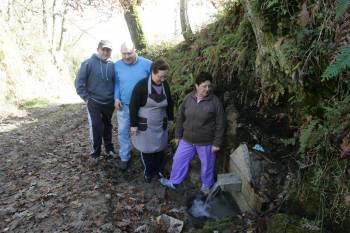 Un grupo de vecinos de Vilela en una de las fuentes restauradas para la ruta castrexa. (Foto: MARCOS ATRIO)
