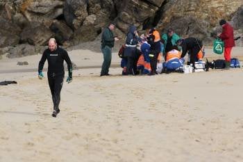 El equipo de sanitarios del 061 intenta reanimar al buceador en la playa de Portomaior. (Foto: ALBERTE)
