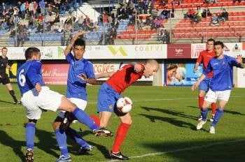 Óscar Martínez, goleador del Ourense ayer, se cuela entre dos jugadores del filial getafense. (Foto: MARTIÑO PINAL)
