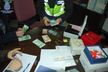 Agentes de la Policía cuentan dinero en uno de los registros domiciliarios. (Foto: DGP)