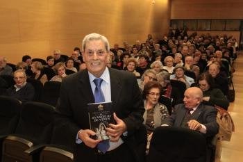 El periodista Alfonso Sobrado Palomares, con el libro que presentaba, ante el público congregado ya antes de la conferencia. 