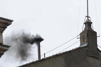Una columna de humo negro emerge de la chimenea sobre el tejado de la Capilla Sixtina.