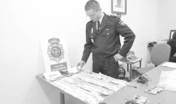 Un policía muestras los billetes incautados en el registro. (Foto: ARCHIVO)