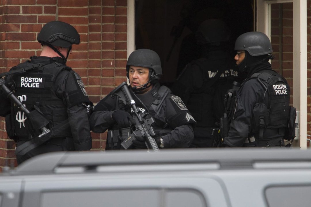 Agentes de distintos cuerpos de policía registran un apartamento en la operación de búsqueda y captura de los dos sospechosos de los atentados de Boston (Foto: EFE)