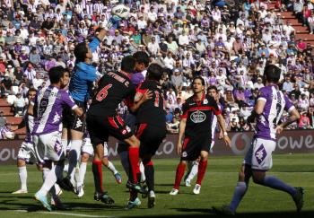 El  portero del Real Valladolid, Jaime Martínez Merlo, despeja un balón en su área rodeado de jugadores del Deportivo y del Valladolid (Foto: EFE)