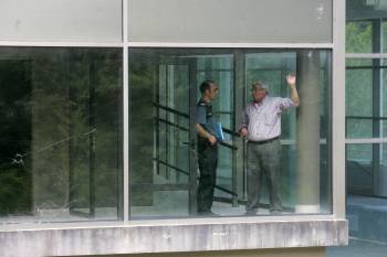 Avelino de Francisco muestra a la Guardia Civil las cristaleras del balneario apedreadas y rotas. (Foto: MIGUEL ÁNGEL)