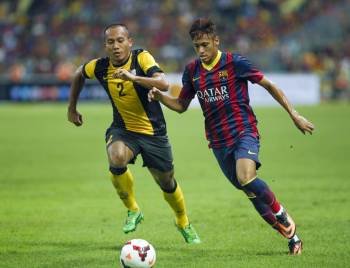 Neymar pelea el balón con Mahalli Jasuli. (Foto: AHMAD YUSNI)